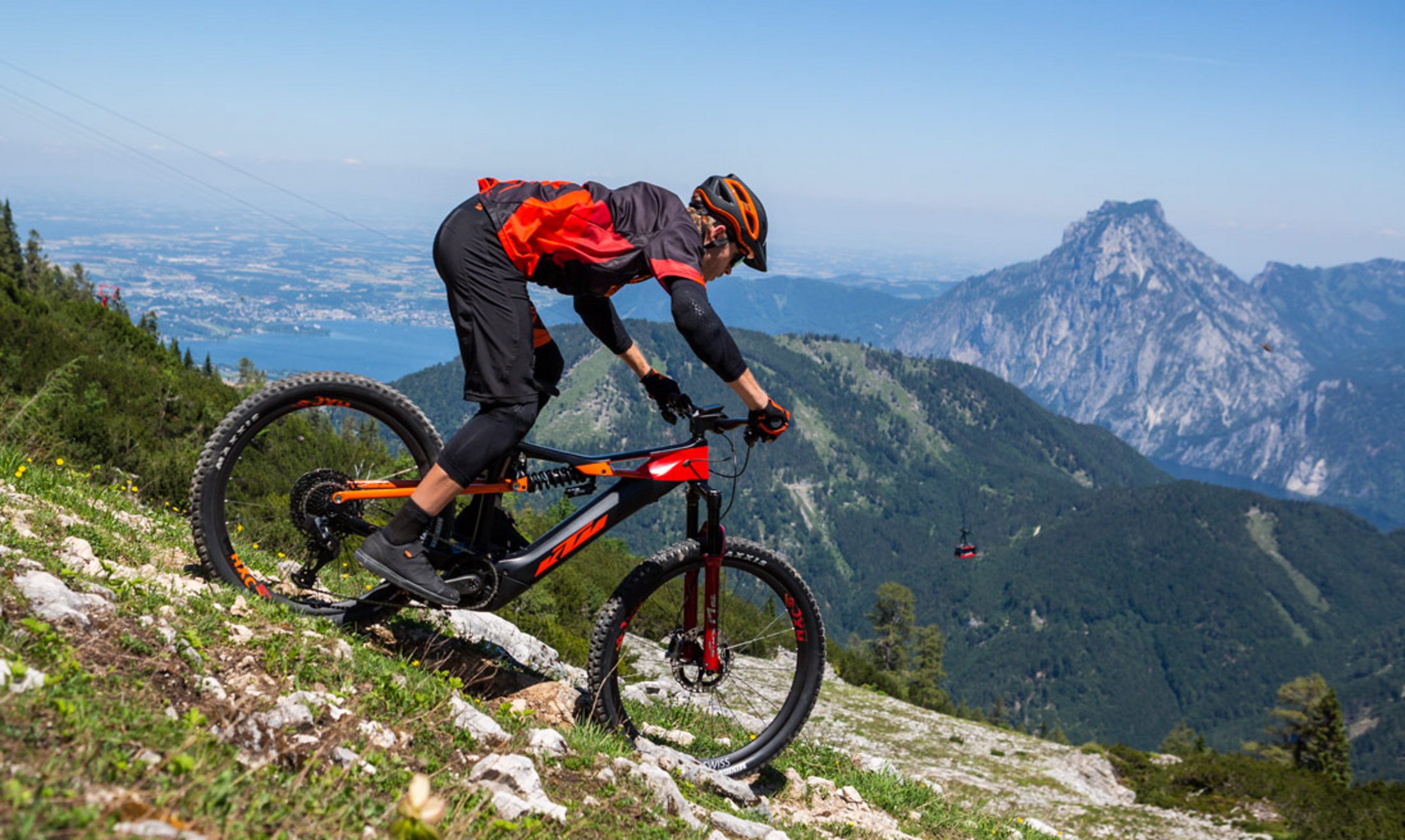 Ein Downhillfahrer fährt bergab in den Alpen. 